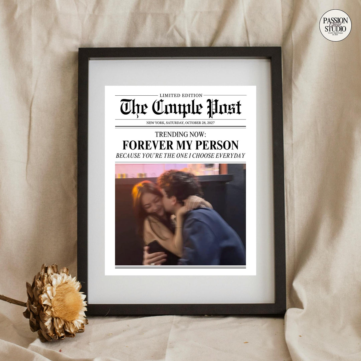 Forever My Person newspaper print in a black frame beside a dried flower